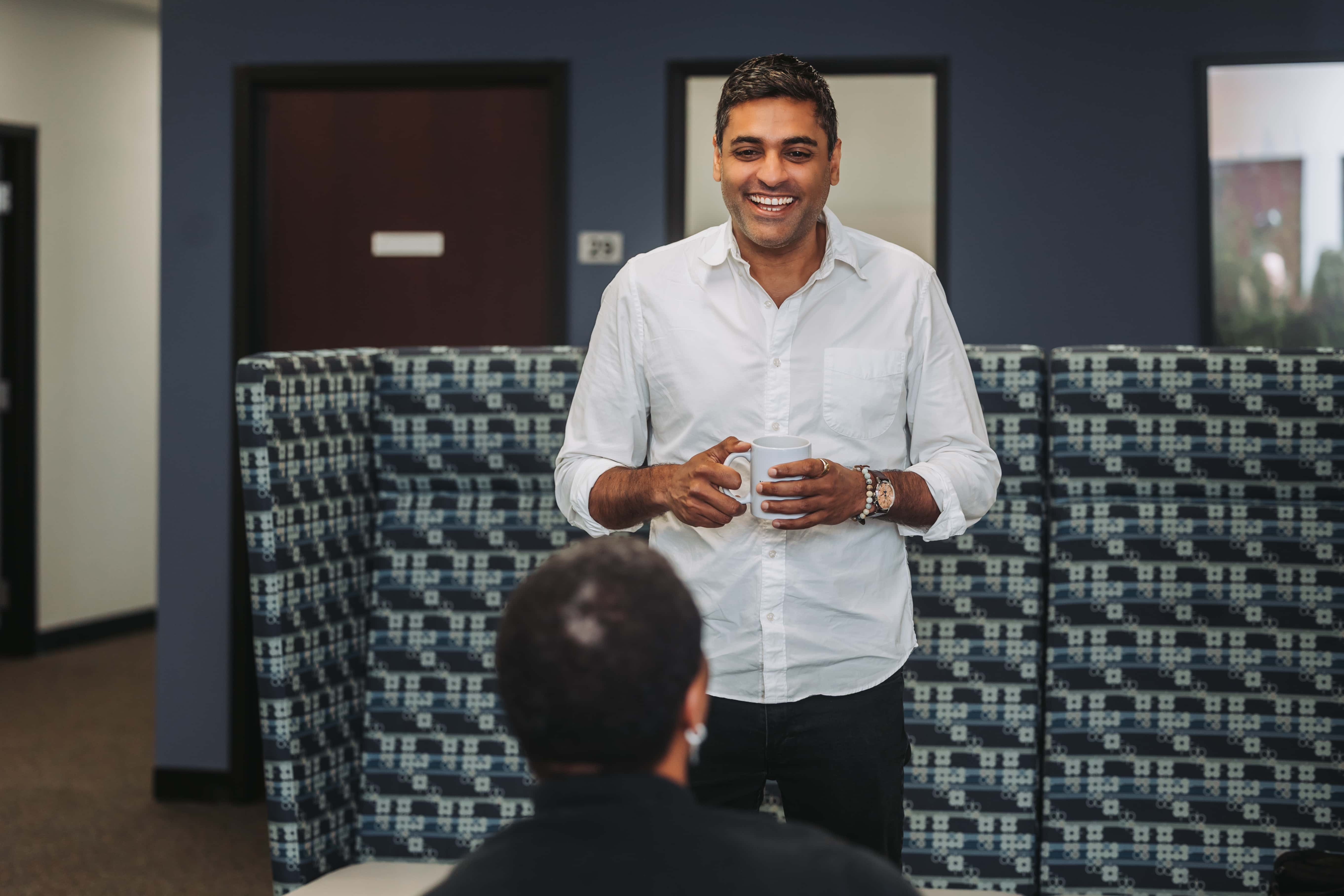 A member chatting over coffee in the Workspace Beverly lounge