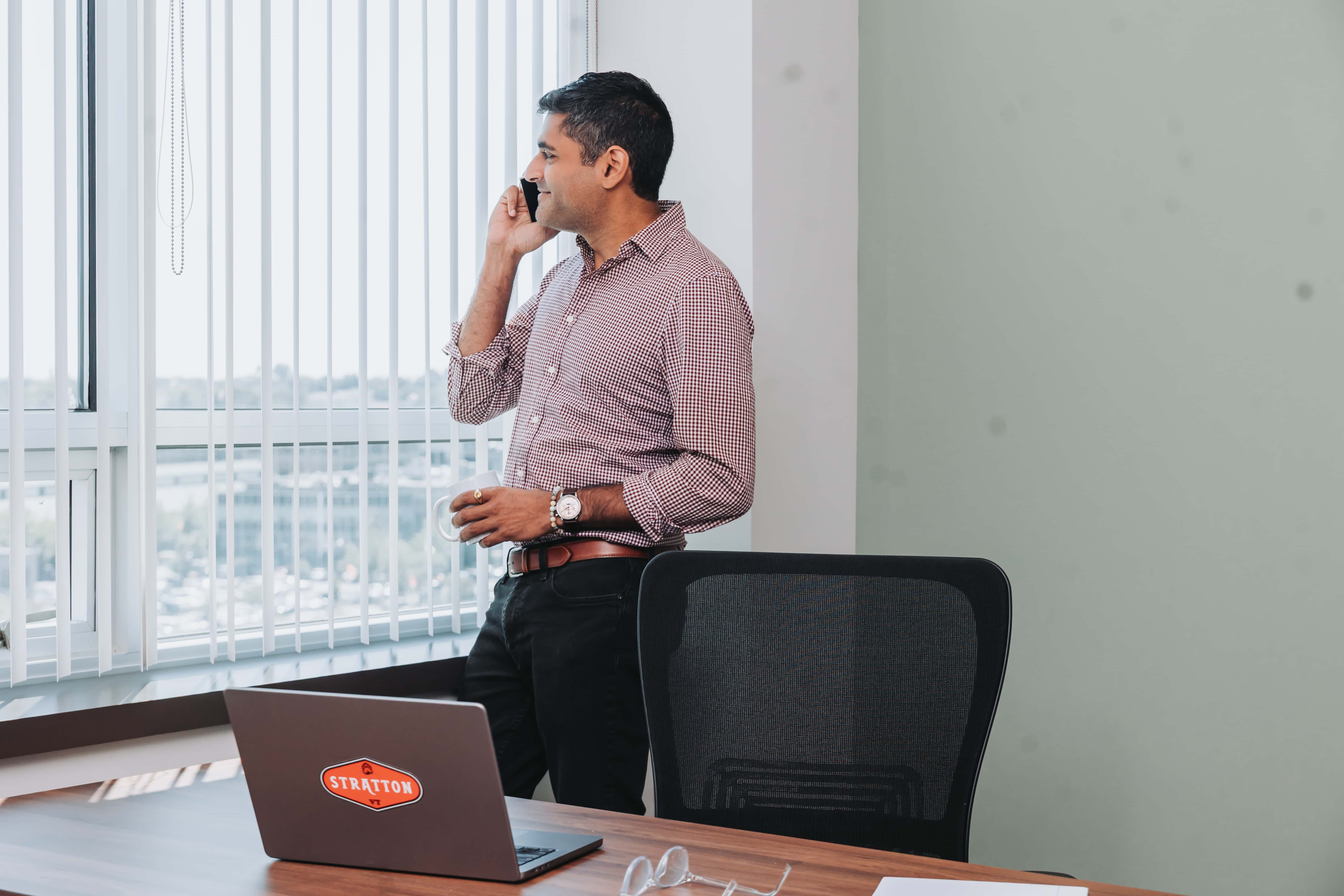 A member taking a call by the window in his Workspace Beverly office