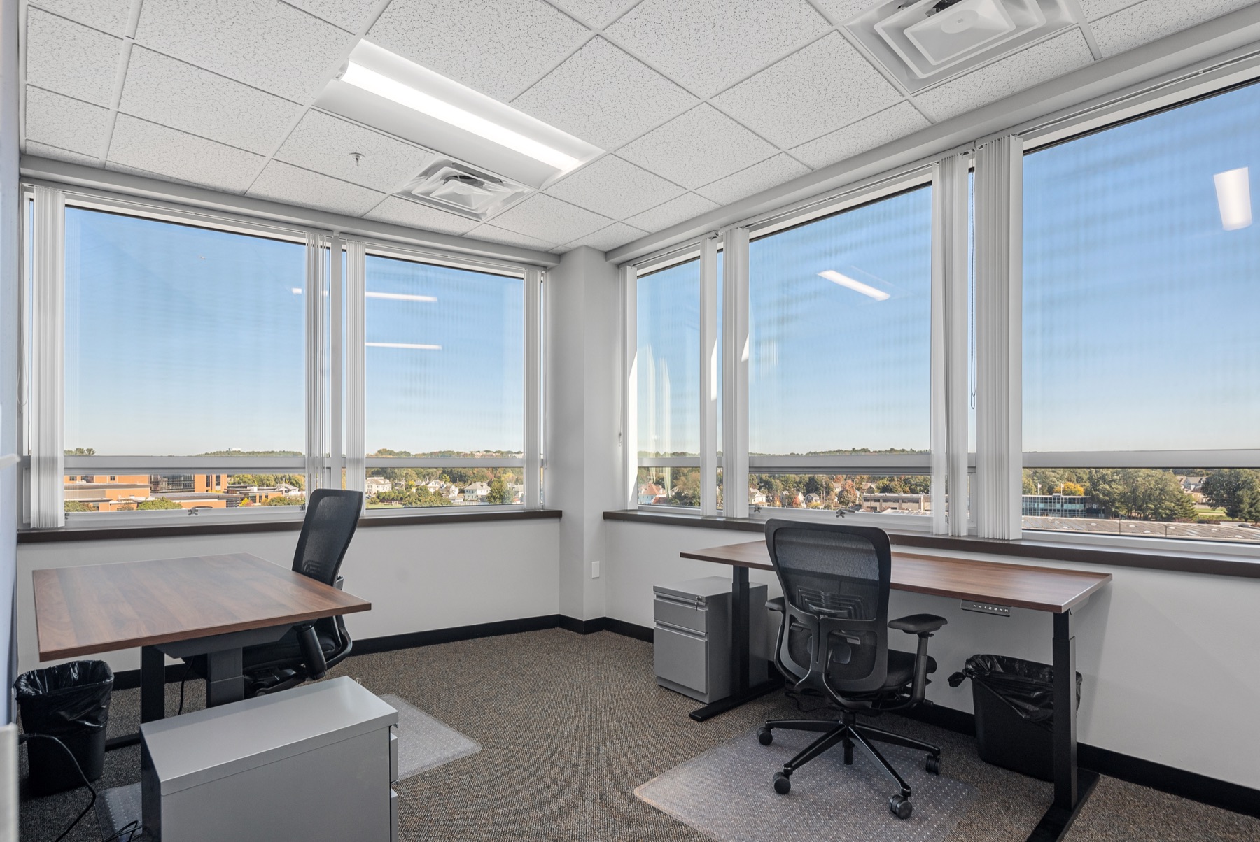 A corner two-desk office at Workspace Beverly with wraparound windows