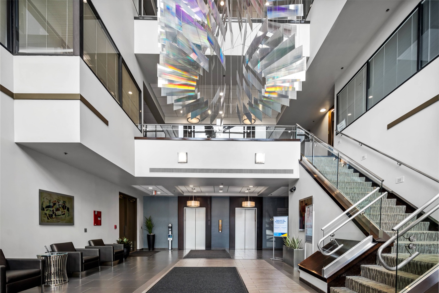 The atrium lobby at Workspace Braintree with its suspended art installation and staircase
