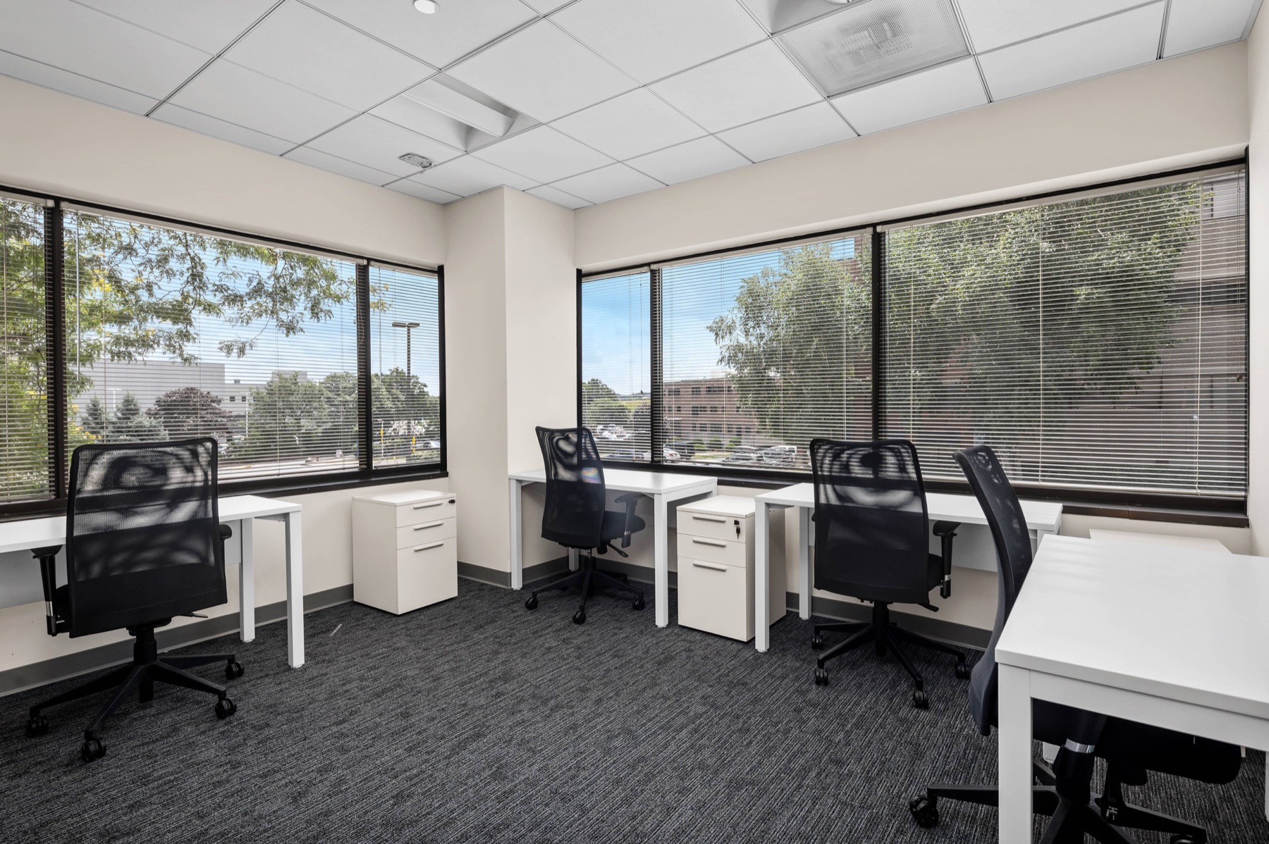 A four-desk team office at Workspace Braintree with tree-lined views