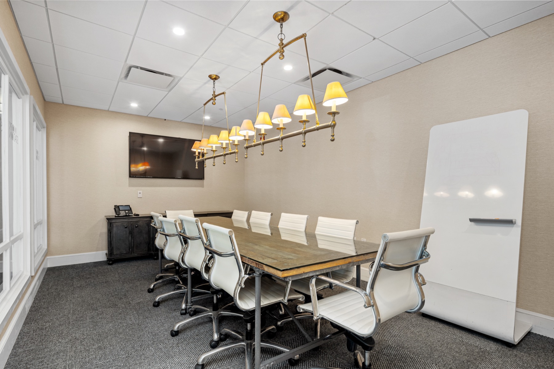 The Cohasset conference room with a ten-seat table, wall-mounted display, and whiteboard