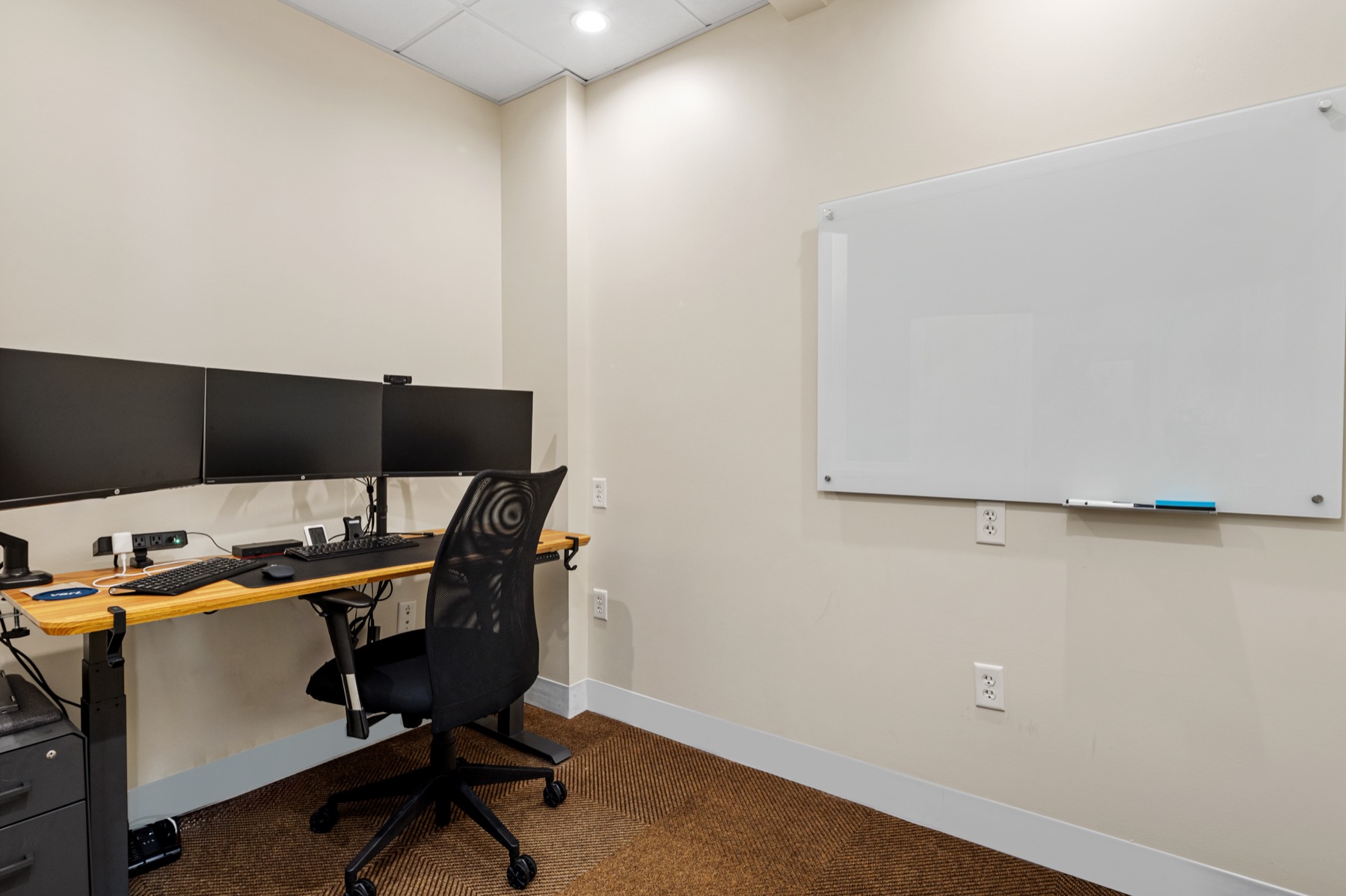 A private office at Workspace Cohasset with a standing desk, dual monitors, and whiteboard