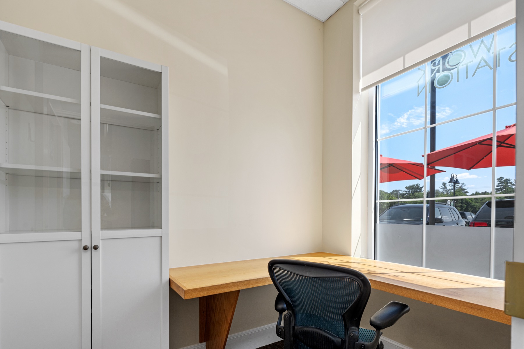 A furnished private office at Workspace Cohasset with a window overlooking Route 3A