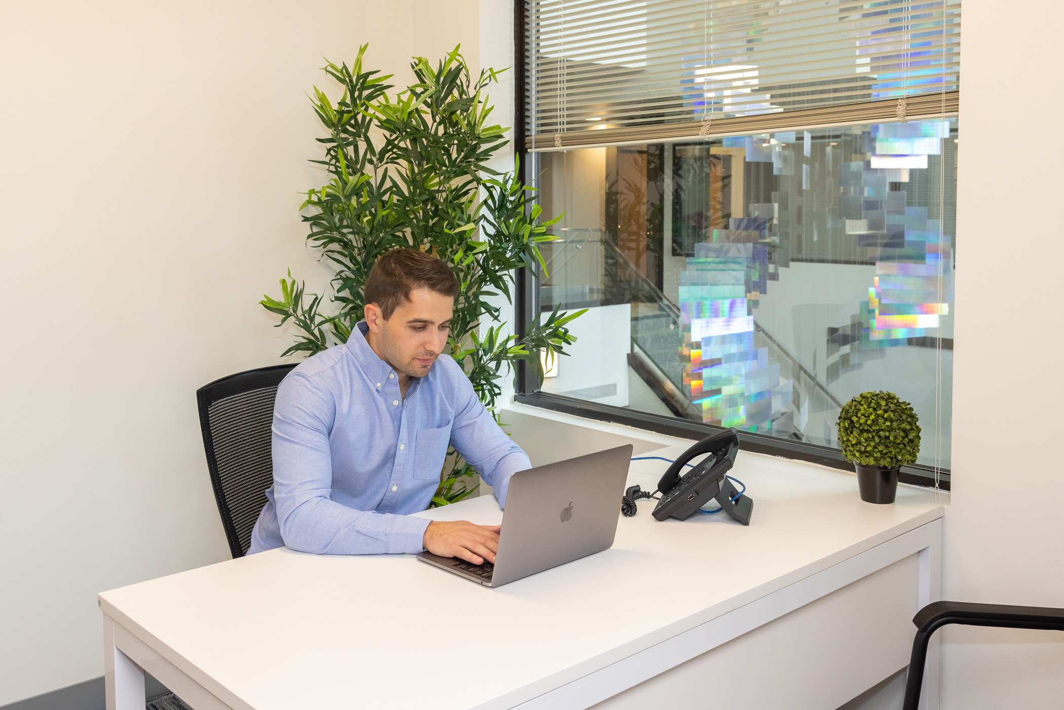 A member working at his desk overlooking the Workspace Braintree atrium