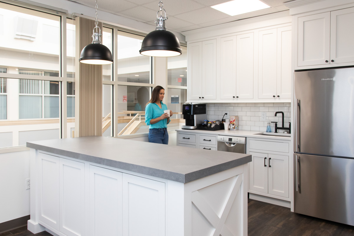 A member grabbing coffee in the Workspace Hingham kitchen