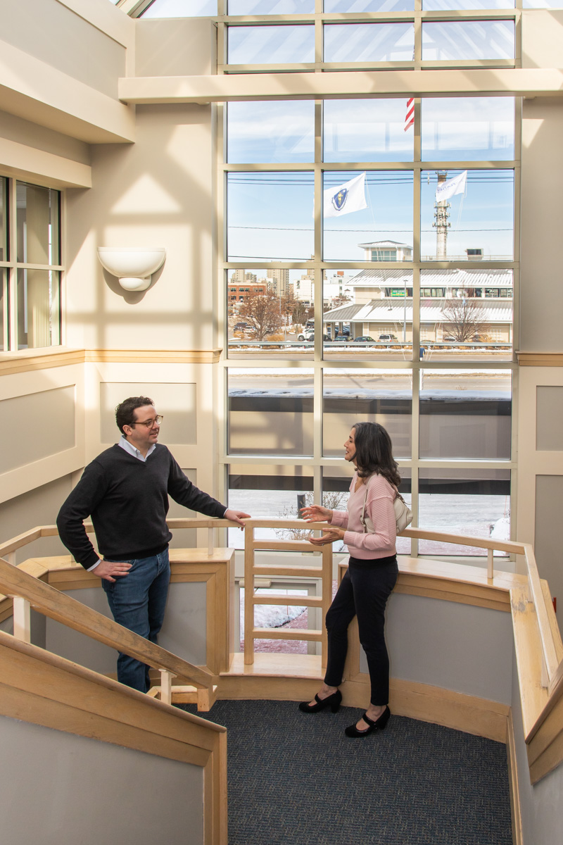 Members chatting on the atrium staircase at Workspace Hingham